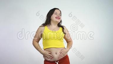 超重的年轻女人<strong>扭动</strong>着肚子，微笑着。 身体正面概念